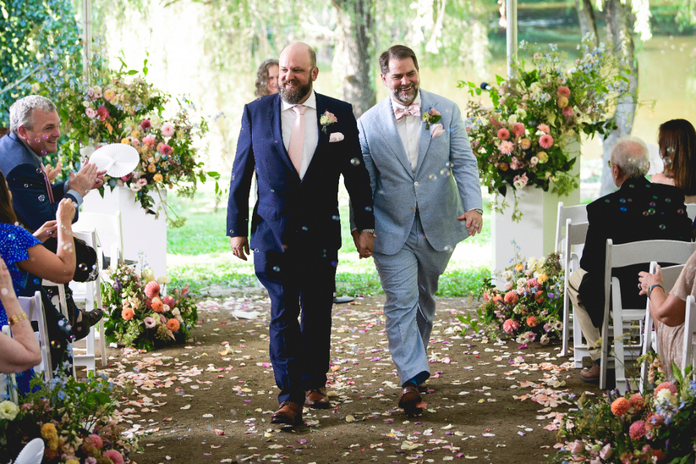 grooms walking down the aisle together after they got married in Milton New York