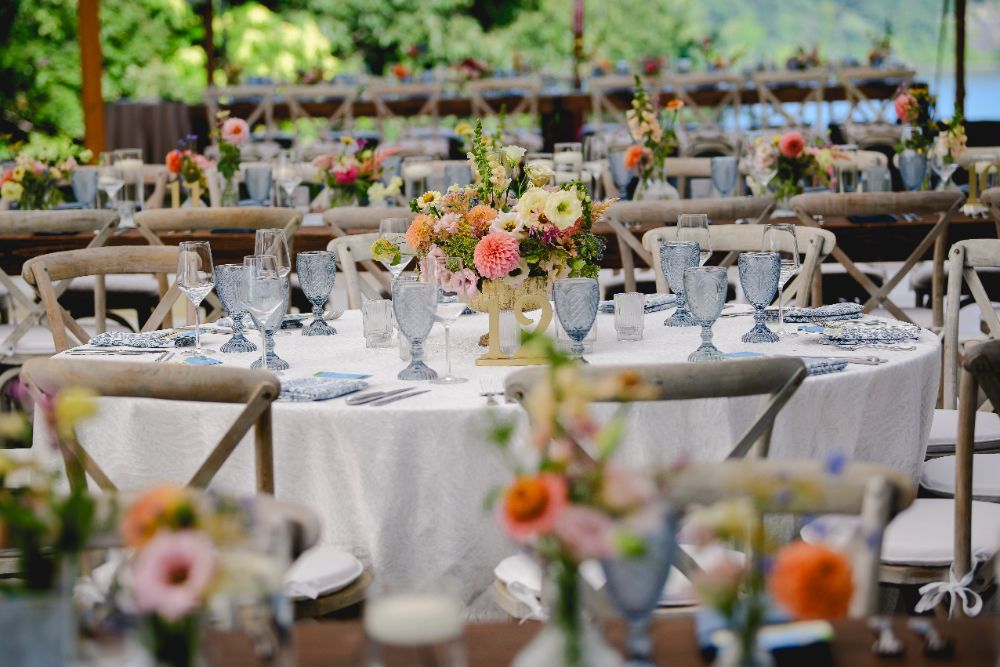 A beautifully arranged wedding table with candles, glassware, and soft-colored florals.