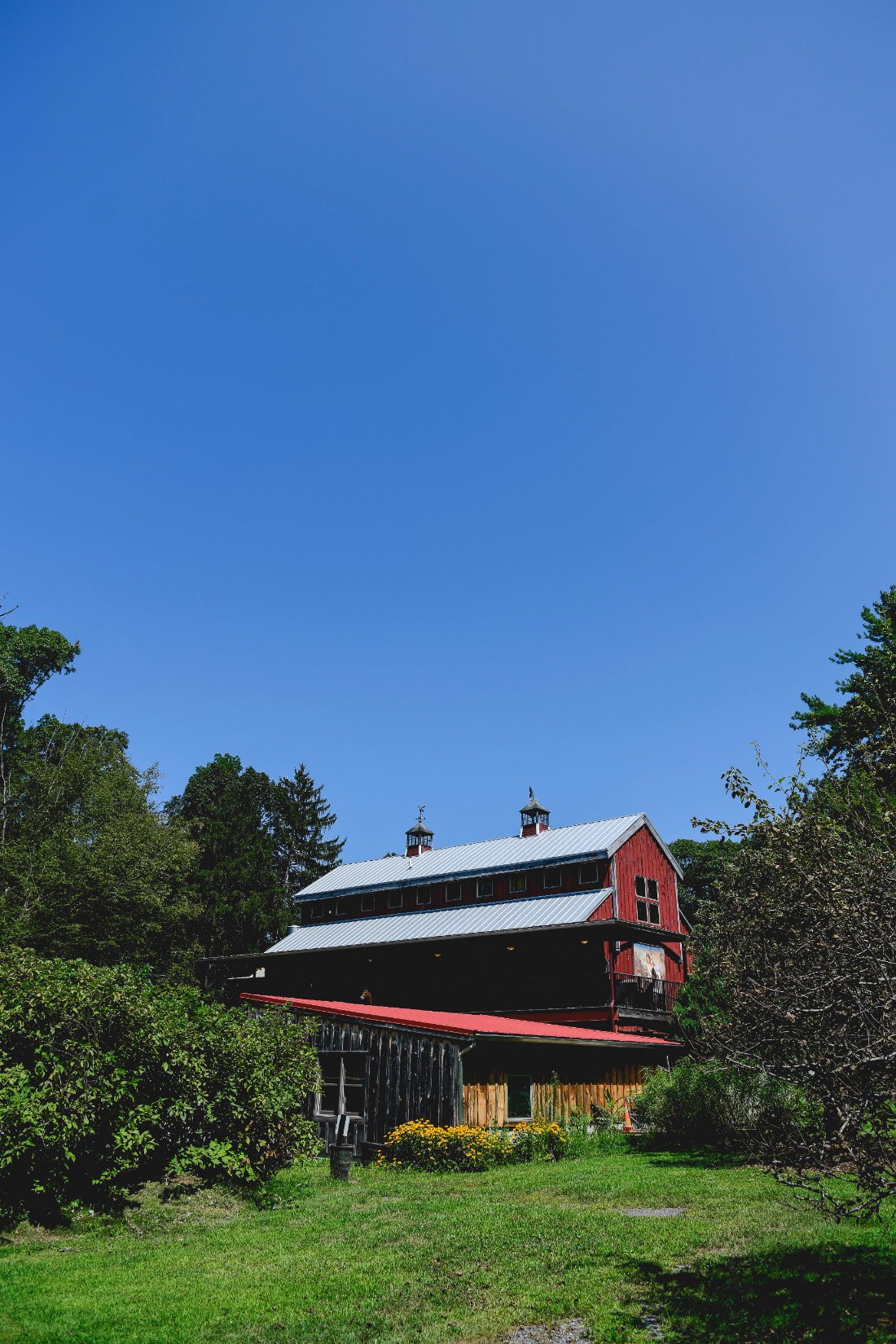 building surrounded by gardens and trees on a sunny day in the Hudson Valley.