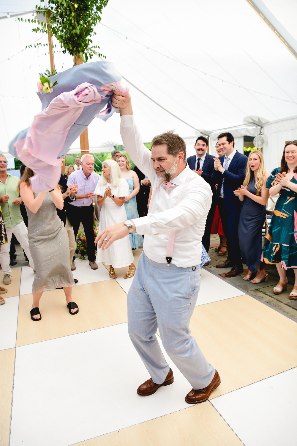 groom enjoying himself on the dance floor swinging suit jacket