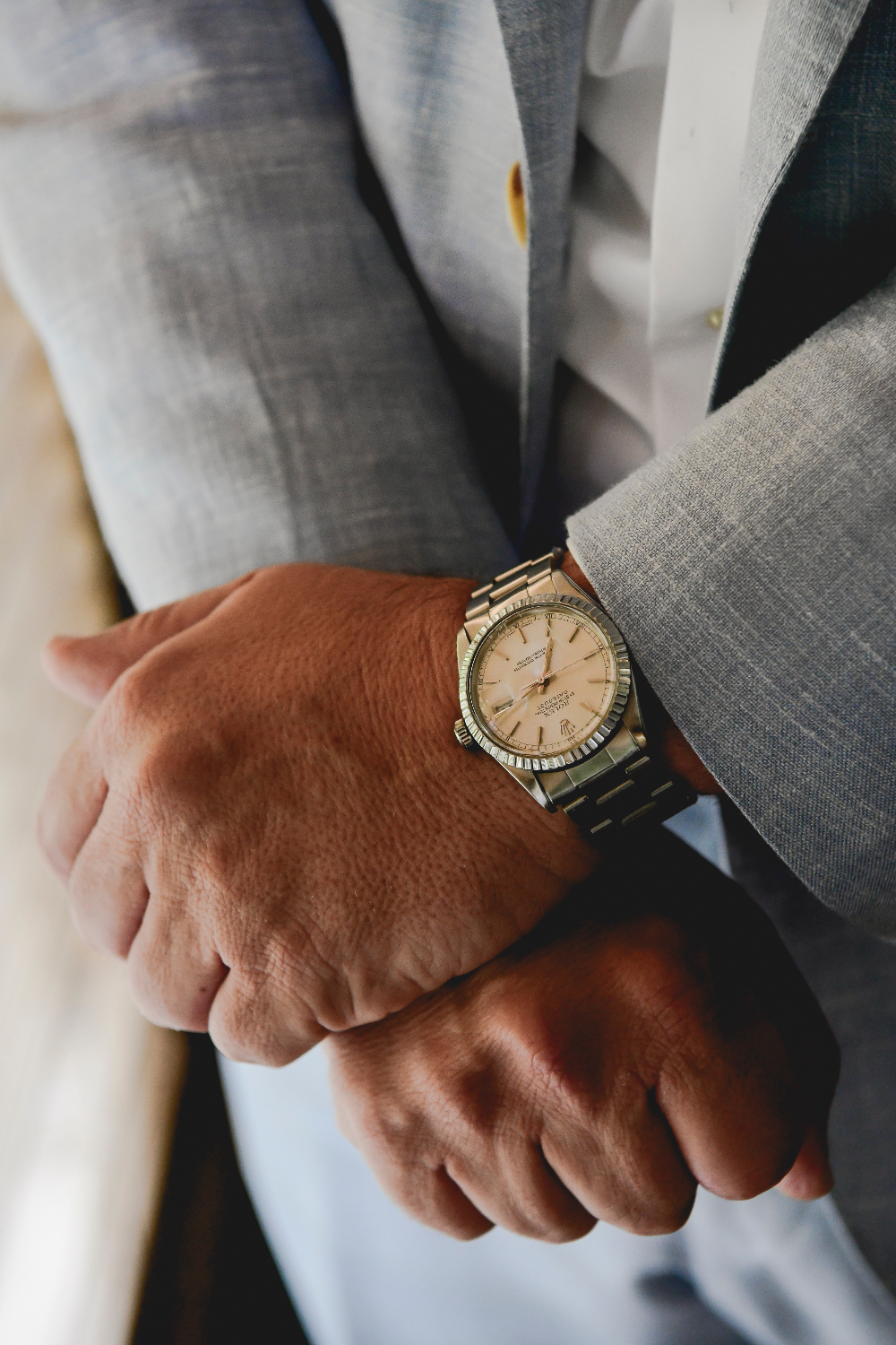 Close-up of a groom’s wristwatch and light blue suit sleeve, photographed during his Buttermilk Falls Inn wedding preparations.