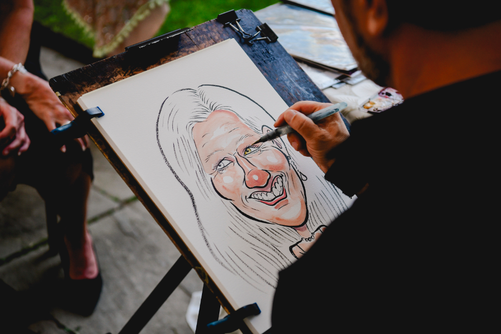 Caricature drawings being created for guests at a Buttermilk Falls Inn wedding.