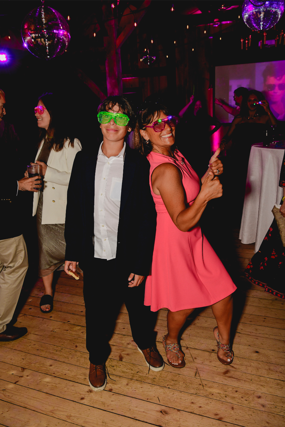 Friends dancing energetically on the neon-lit dance floor.