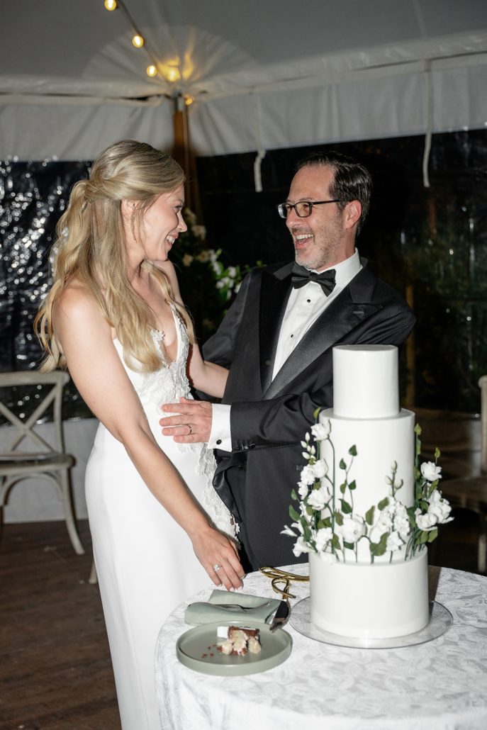 Bride and groom cutting the cake and smiling