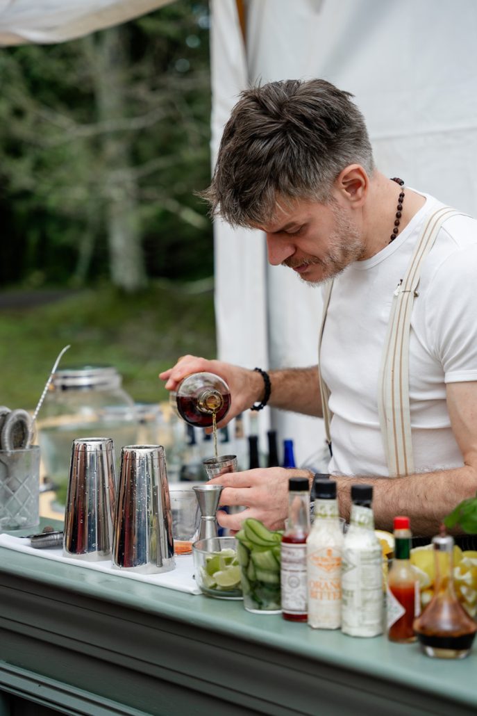 Bartender pouring drinks at the bar showing how to plan a home wedding cocktail service
