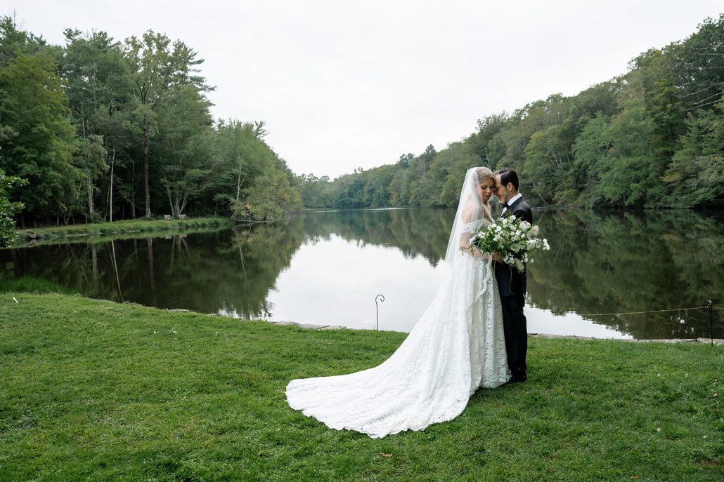 bride and groom just after their ceremony stopping to take photos near the lake