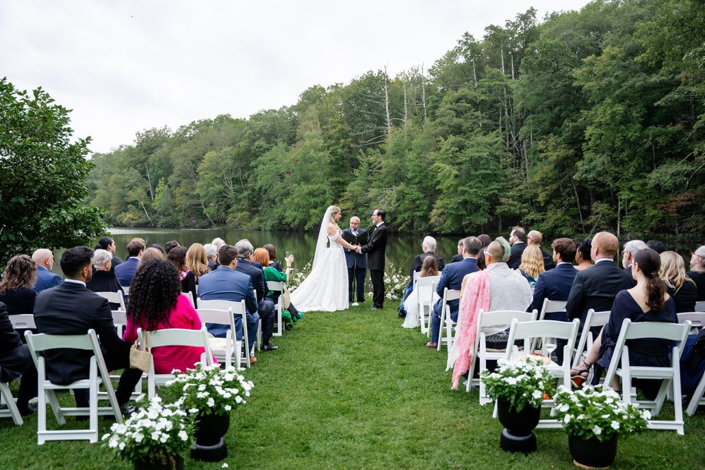 Ceremony view of couple at the end of the aisle hand in hand showing how to plan a home wedding ceremony
