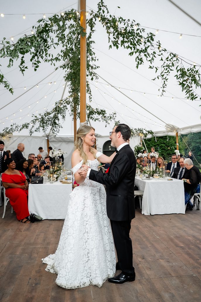 Bride and groom dancing together under the tent at their home wedding