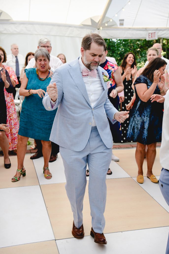 Guest dancing on the reception dance floor, surrounded by cheering friends and family.