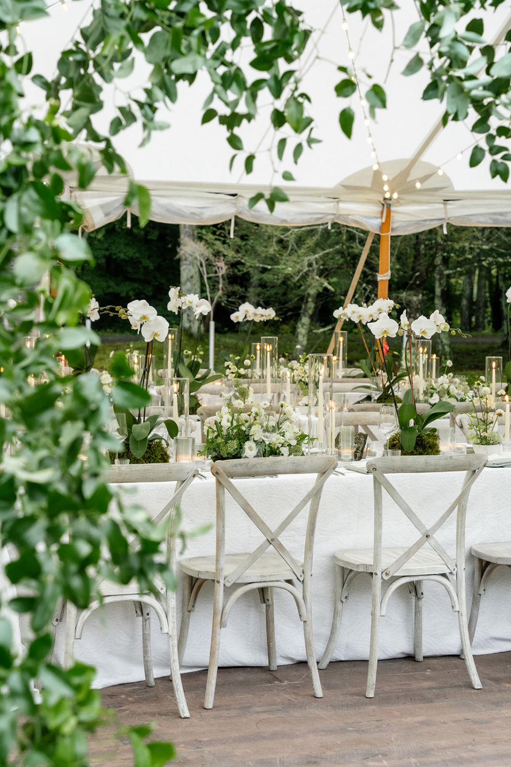 Elegant tented reception with white florals and candlelight, showing how much does a luxury wedding cost through rentals, production, and design