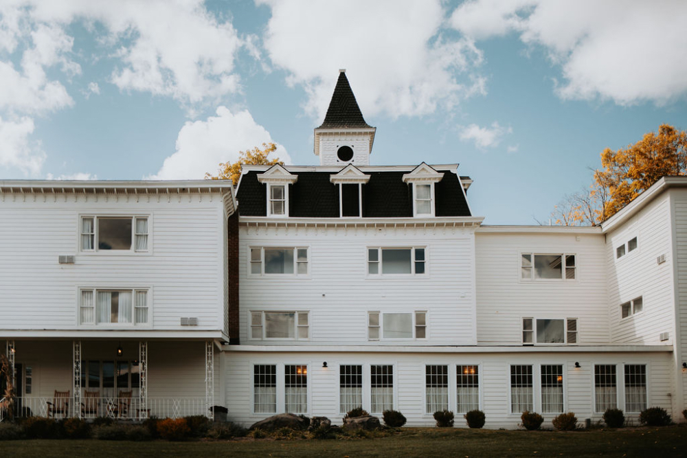 Exterior view of a charming wedding venue with classic white architecture and expansive grounds