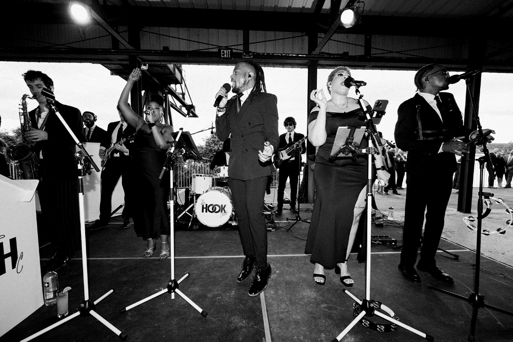 Live wedding band performing on stage at a stylish reception, showing how much does a luxury wedding cost can include premium entertainment