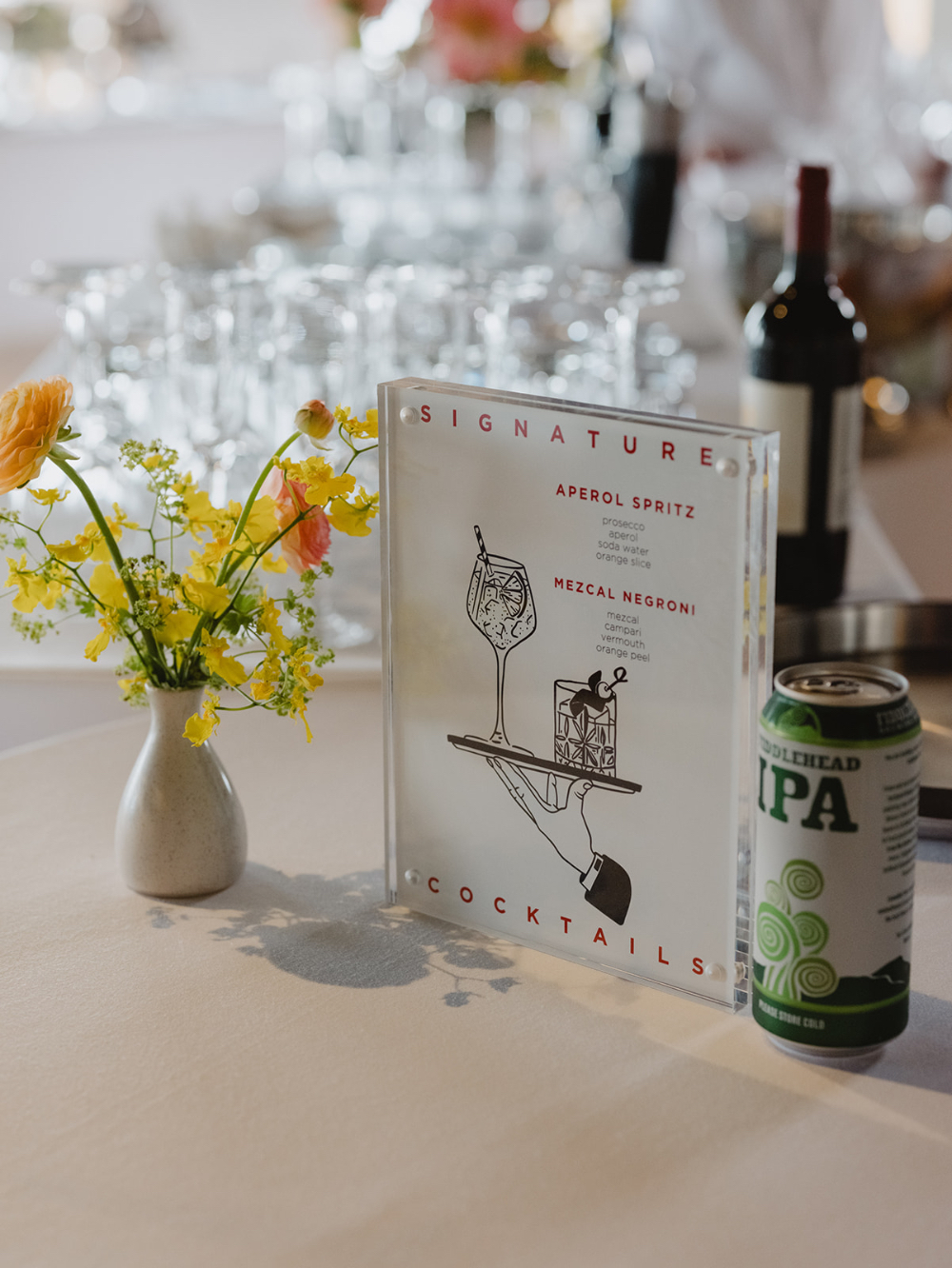 Signature cocktail display with custom drink menu and floral accents, highlighting how much does a luxury wedding cost through elevated guest experience details