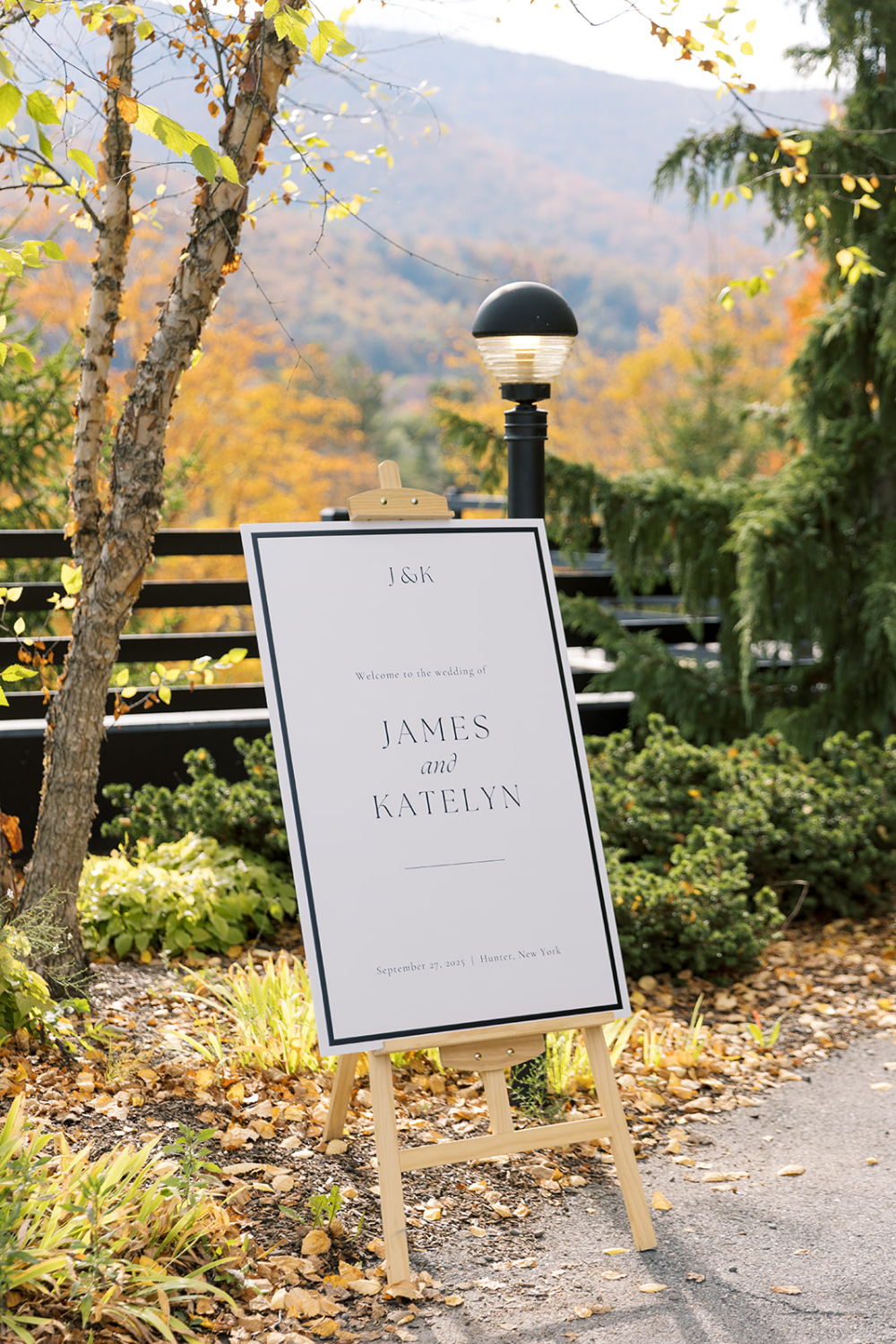 Elegant wedding welcome sign on easel with mountain backdrop in early fall, reflecting thoughtful wedding planner responsibilities