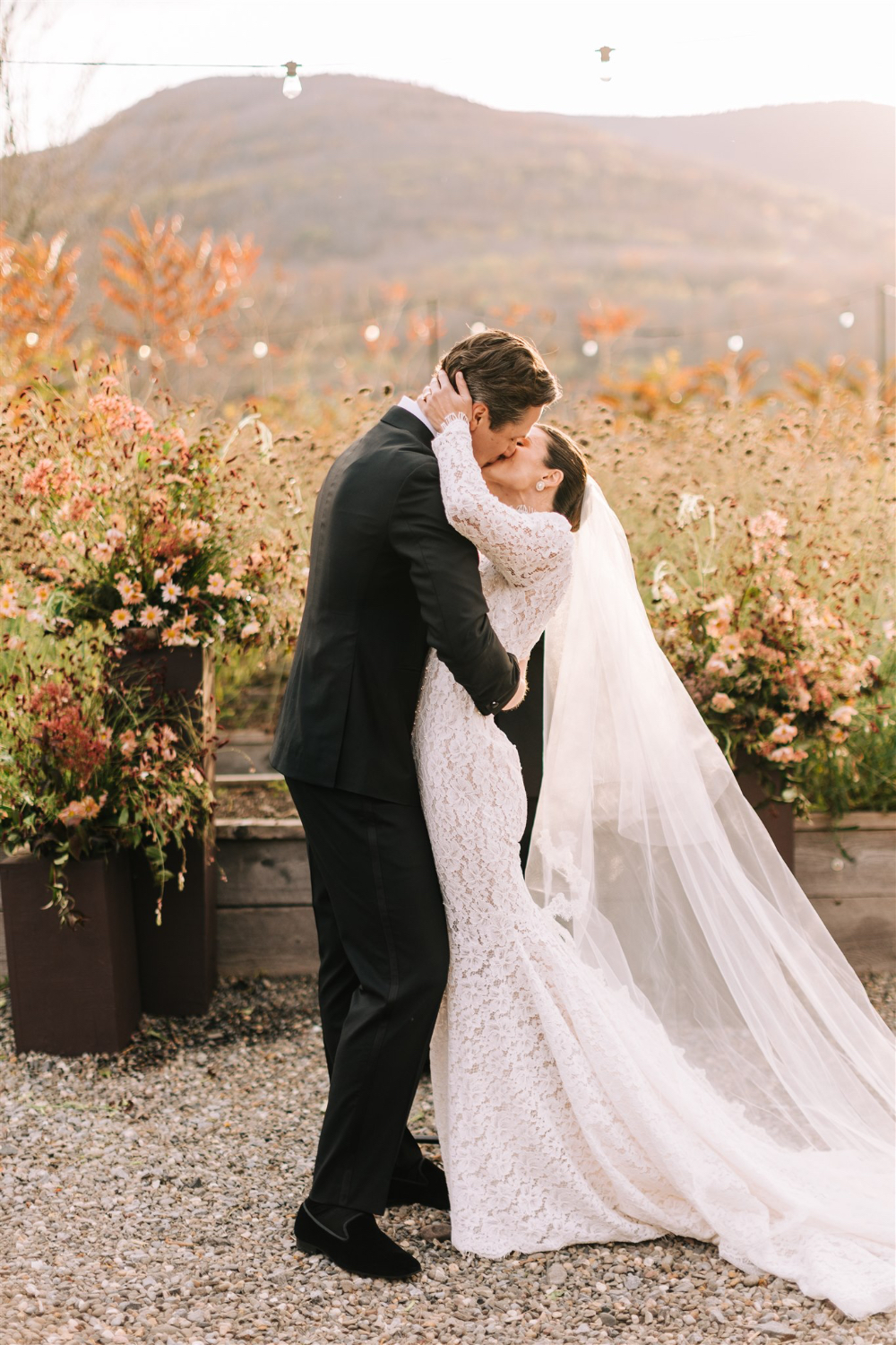 Bride and groom sharing a kiss outdoors with mountain views during golden hour