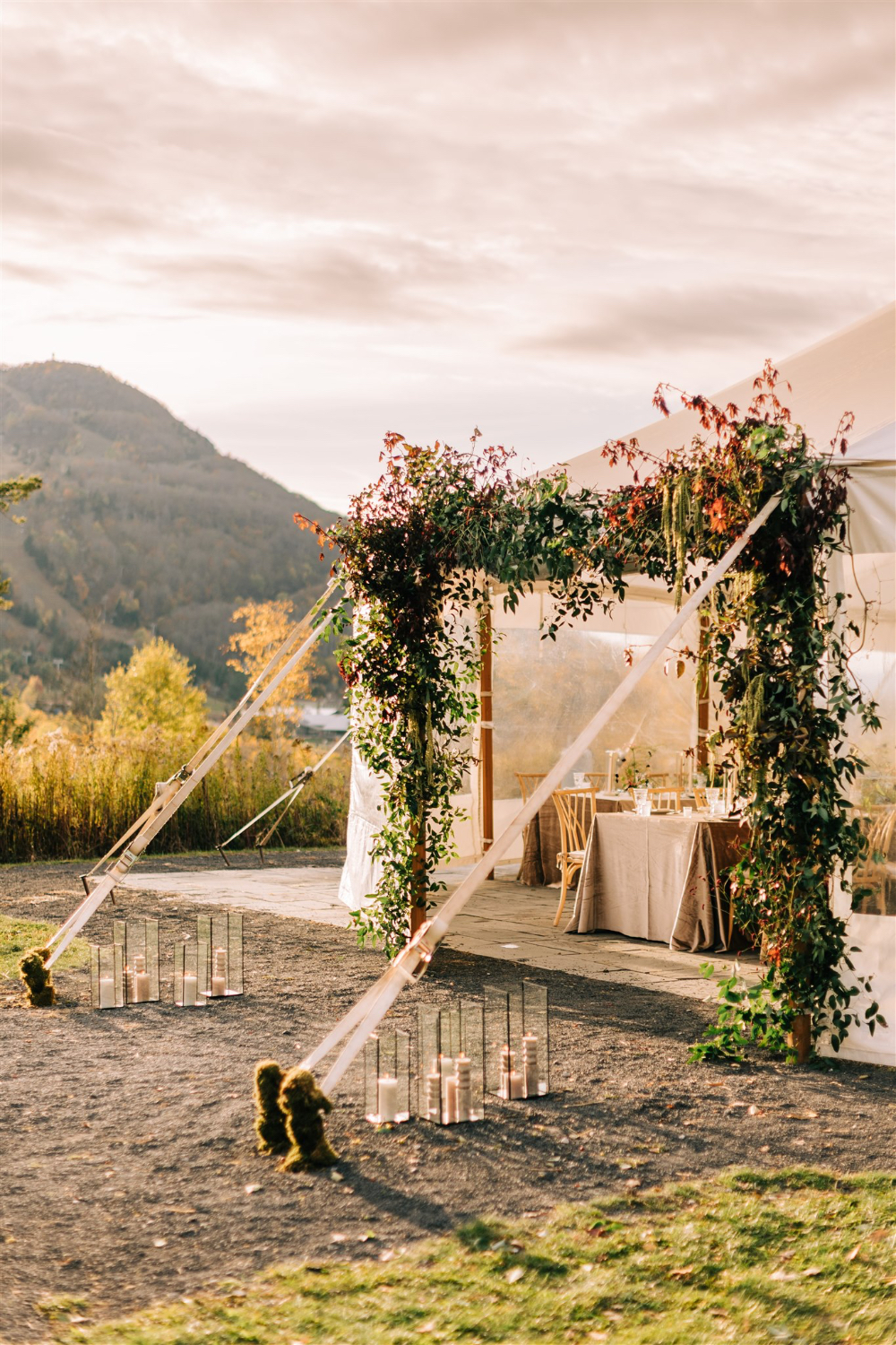 Clear-top tent entrance with lush greenery and candle accents, reflecting seamless wedding planner responsibilities