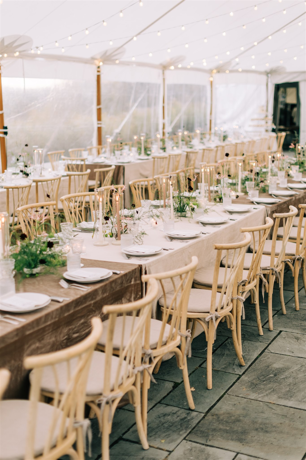Reception tablescape with neutral linens, wooden chairs, and delicate floral details, styled through wedding planner responsibilities