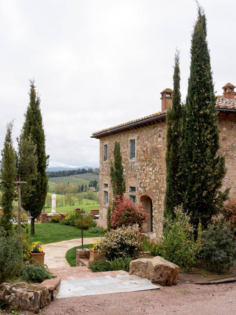 Rustic Tuscan estate with cypress trees and rolling countryside views.