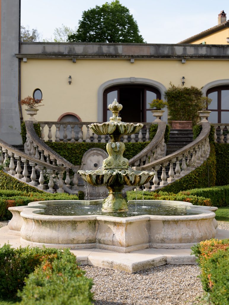 Ornamental fountain and formal gardens at a luxury Tuscany destination wedding Italy venue.