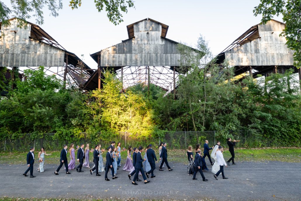 Wedding party walking toward a unique industrial venue during a venue scouting inspired celebration in New York.