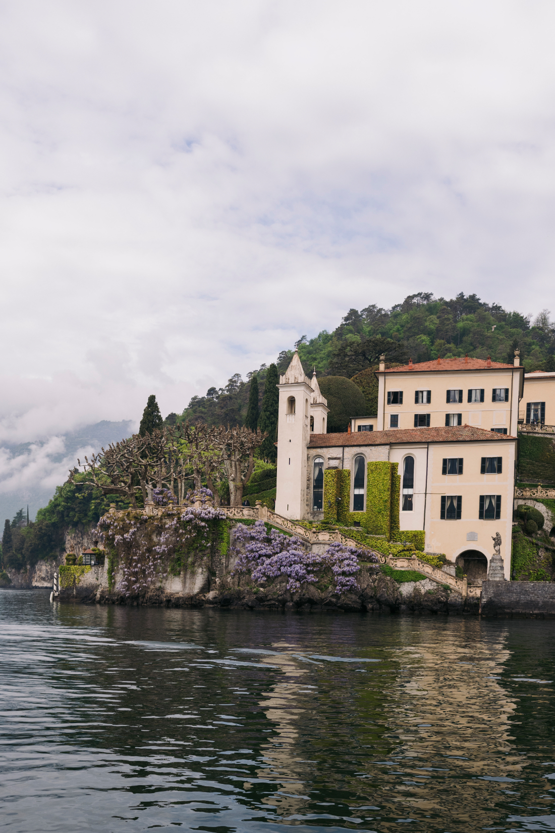 Close-up of the lakeside façade and blooming wisteria at a Villa del Balbianello wedding on Lake Como.