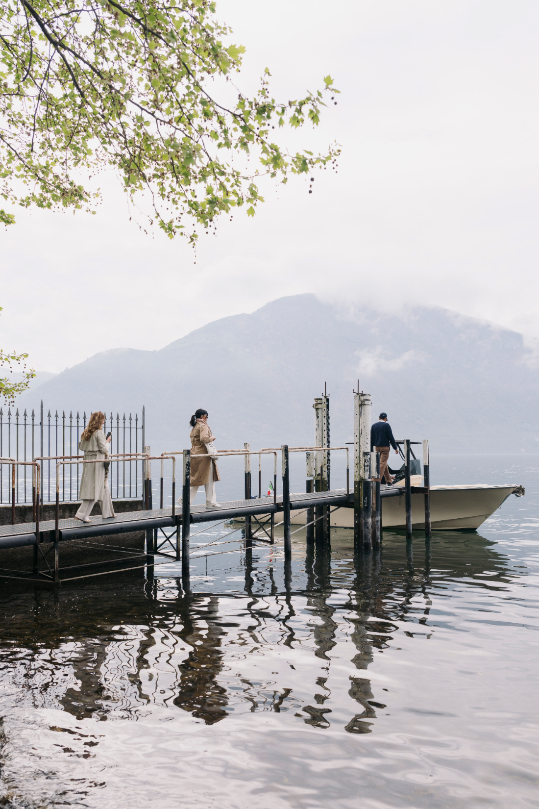 Guests walking along a private pier to board a boat for a Villa del Balbianello wedding on Lake Como.