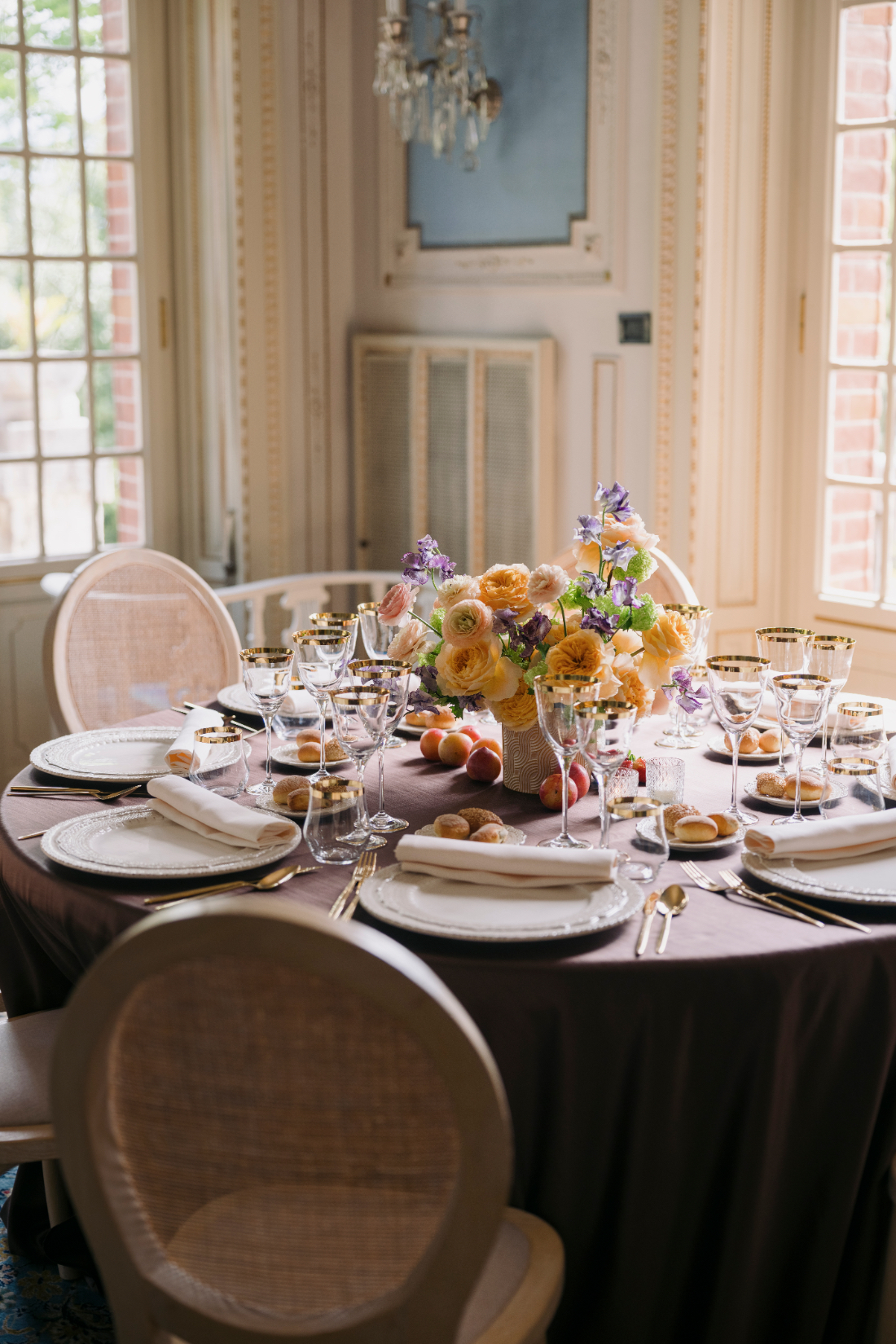Romantic wedding table with floral centrepiece beside large windows