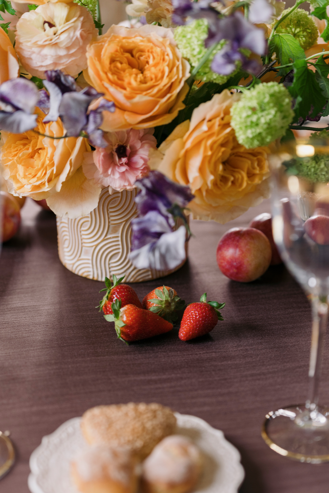 Close-up of colourful wedding flowers and seasonal fruit tablescape