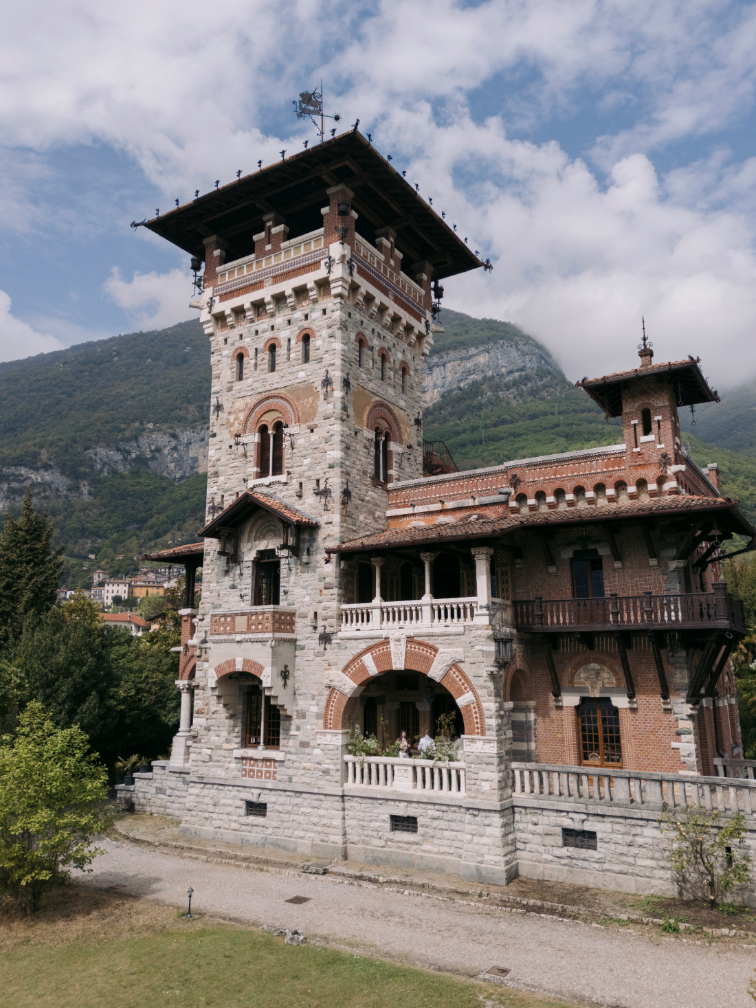 Historic stone and brick façade of Villa Pessina with mountain views