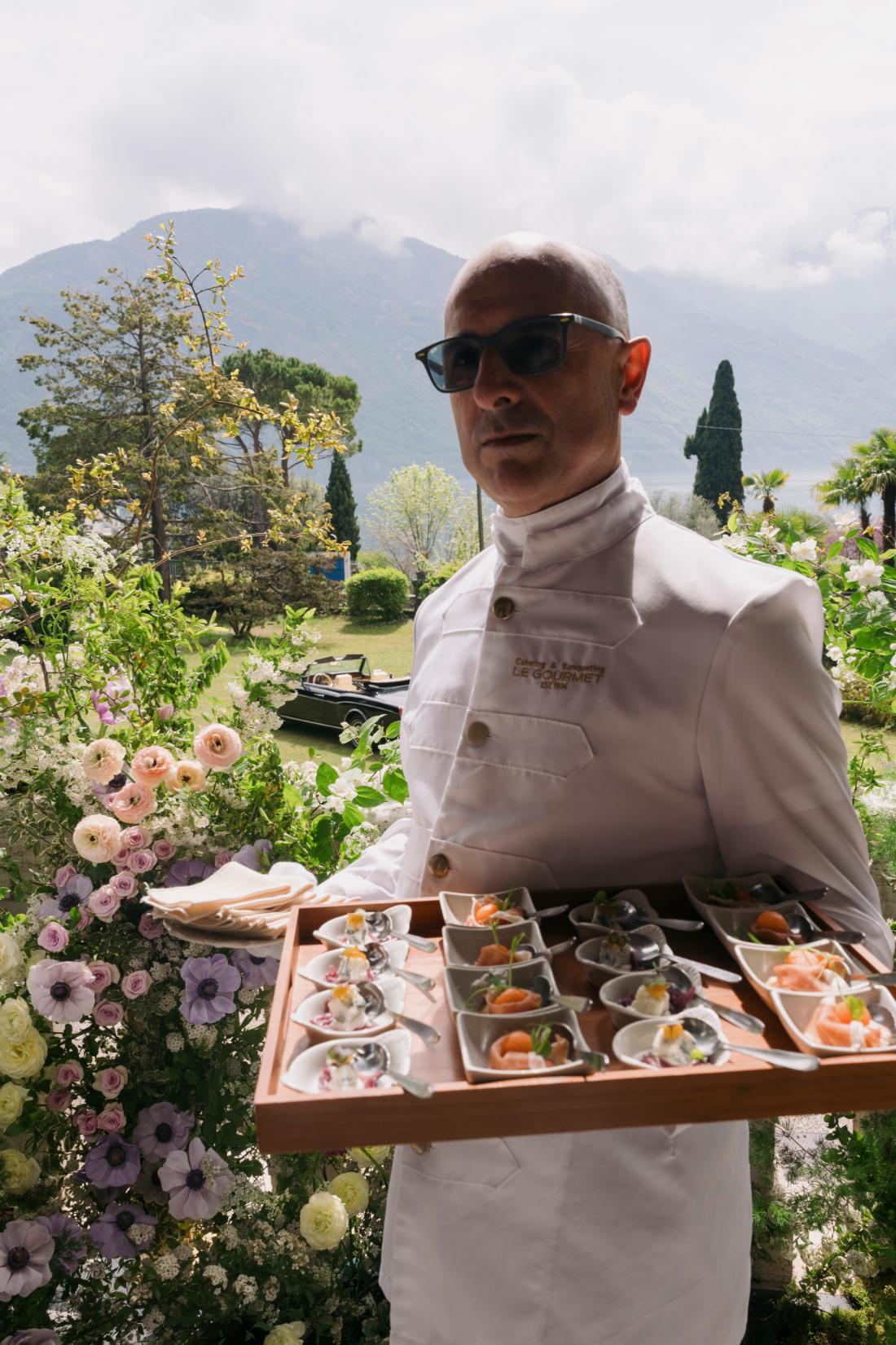 Caterer serving gourmet wedding canapés with Lake Como views