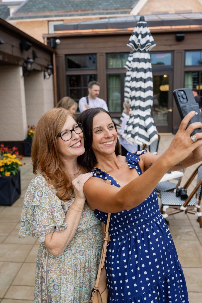 Two guests taking a selfie during cocktails at the Mirbeau Beacon industry gathering
