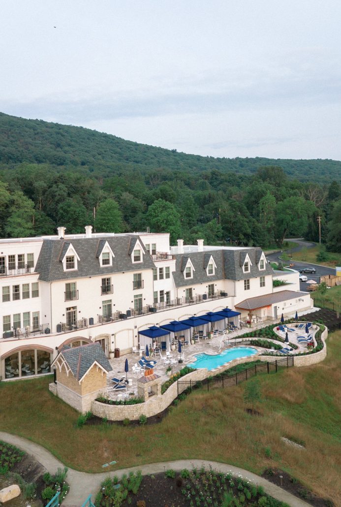 Aerial view of Mirbeau Beacon spa, pool and guest accommodations surrounded by Hudson Valley greenery