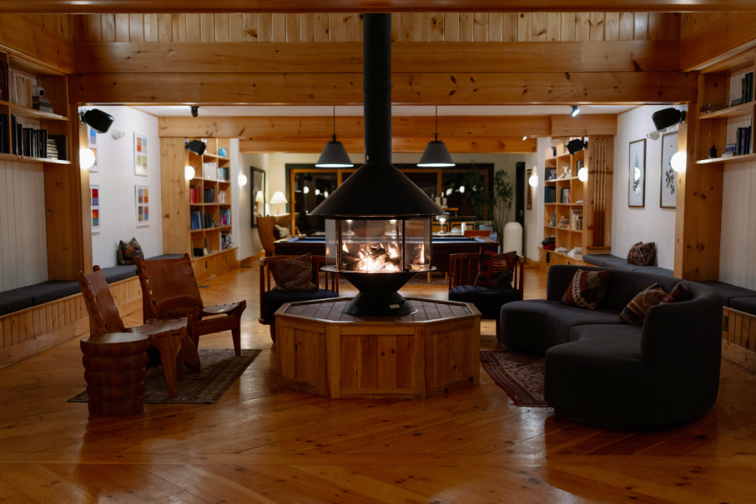 Cozy indoor wedding lounge with a central fireplace and comfortable seating for an intimate late-night gathering.