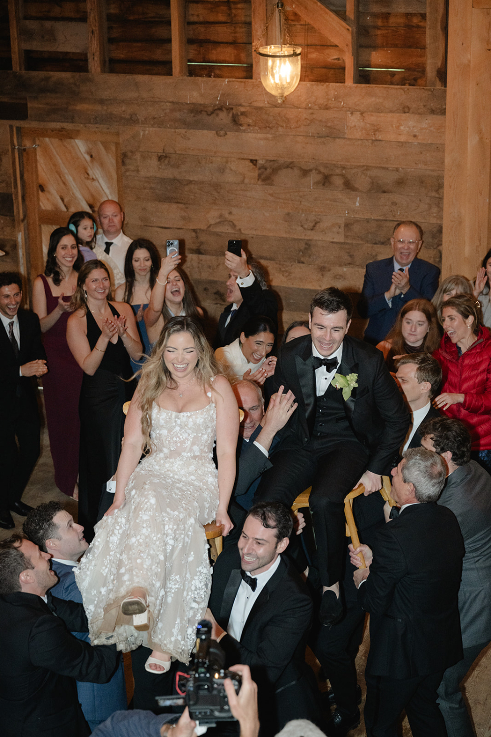 Newlyweds celebrating with family and friends while their planner handles wedding planning stress behind the scenes.