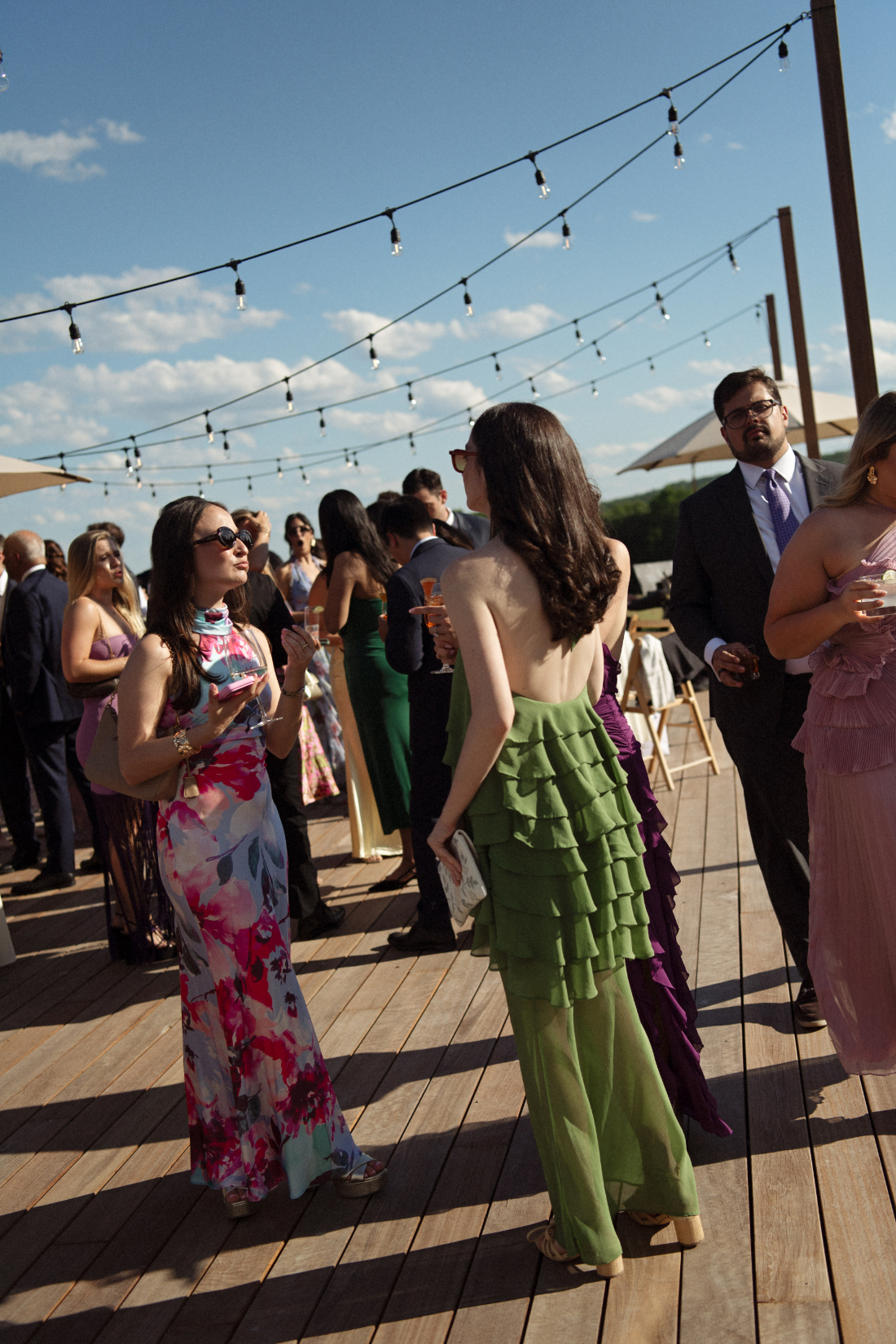 Guests enjoying cocktails outdoors beneath string lights during an east coast wedding celebration 