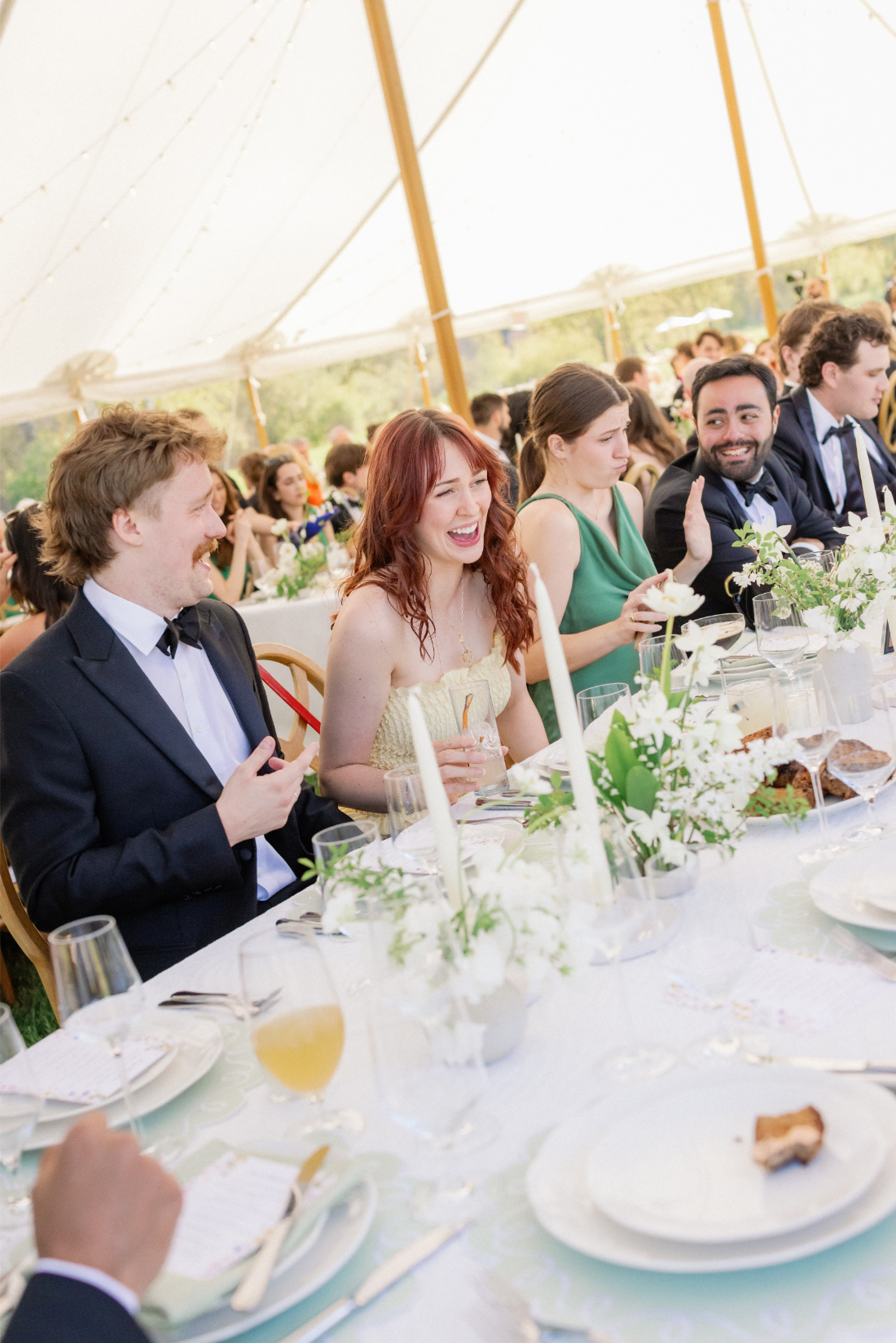 Guests enjoying an elegant tented dinner during an east coast wedding reception 